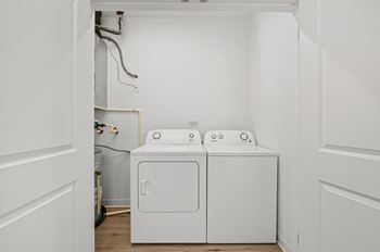 A white washing machine and dryer in a small laundry room.